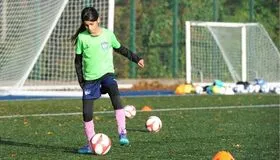 Young girl practising football footwork drill during EFA training session in London - girls football programme in London